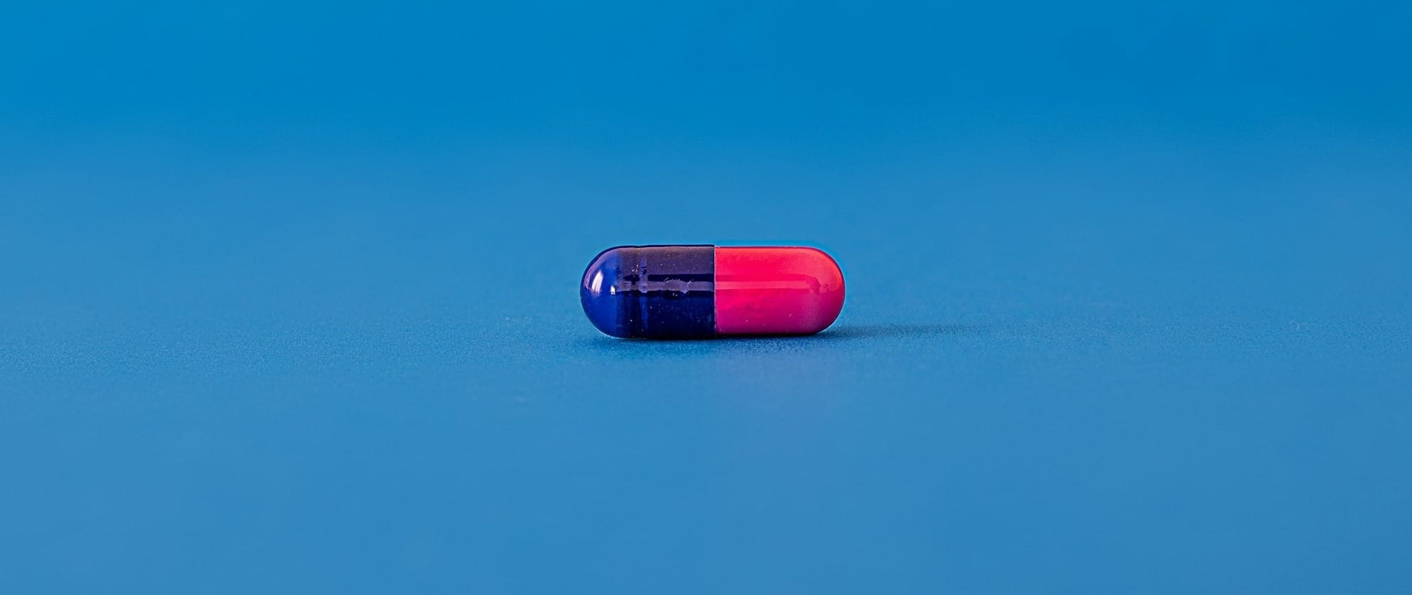 red and blue pill on blue surface