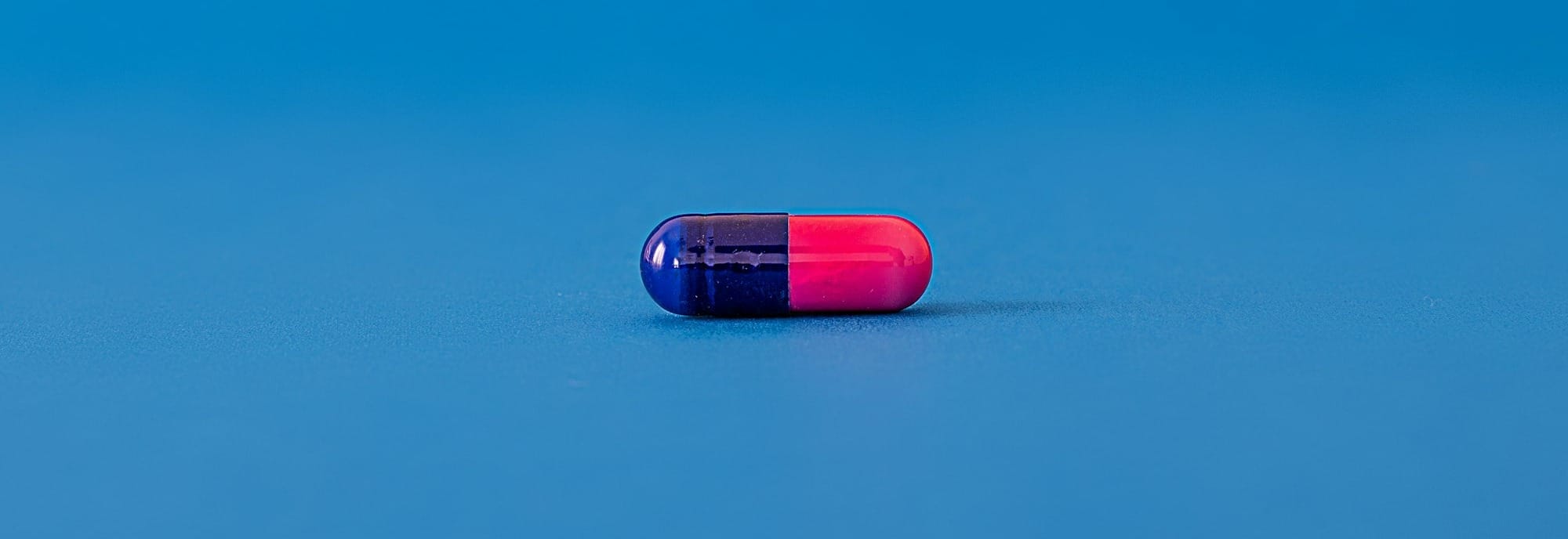 red and blue pill on blue surface